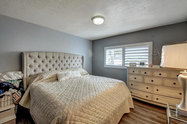 bedroom with dark hardwood / wood-style flooring and a textured ceiling