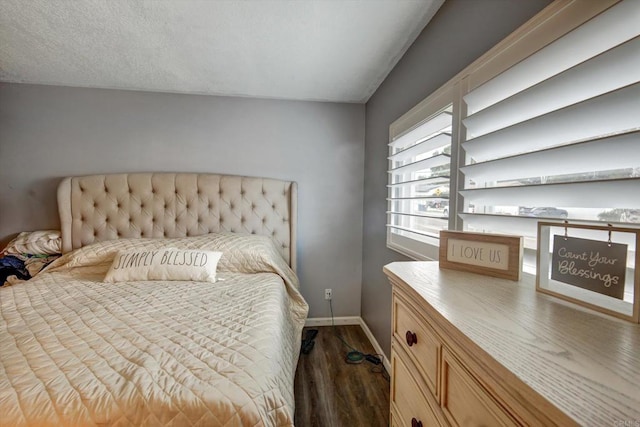 bedroom featuring a textured ceiling and dark hardwood / wood-style flooring