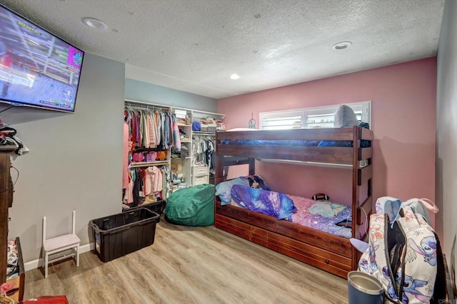 bedroom featuring a textured ceiling, light wood-type flooring, and a closet