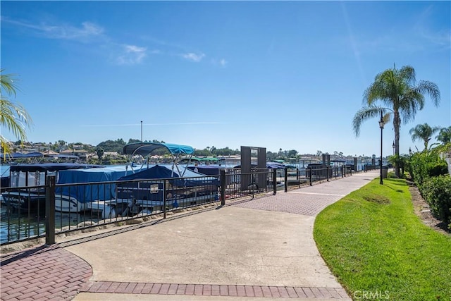 view of community featuring a lawn and a boat dock