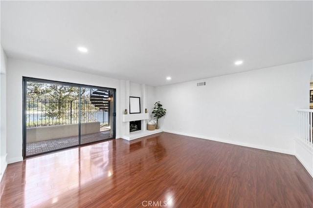 unfurnished living room with wood-type flooring and a fireplace