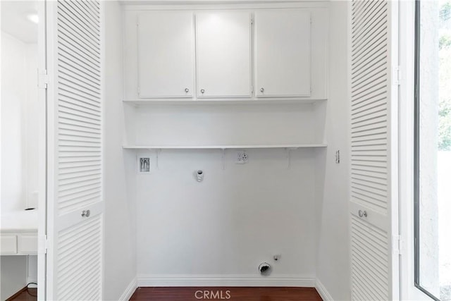 washroom featuring dark hardwood / wood-style flooring, hookup for a gas dryer, plenty of natural light, and cabinets