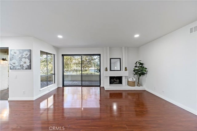 unfurnished living room featuring a fireplace and dark wood-type flooring