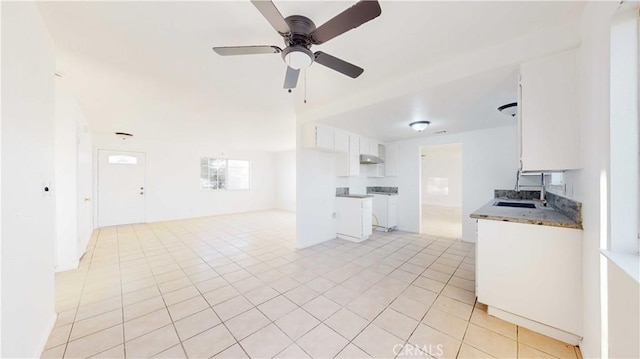 kitchen with ceiling fan, light tile patterned floors, sink, and white cabinetry