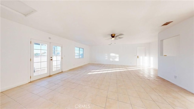 tiled empty room with ceiling fan and french doors