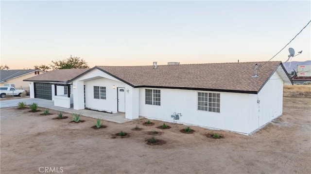 back house at dusk with a garage