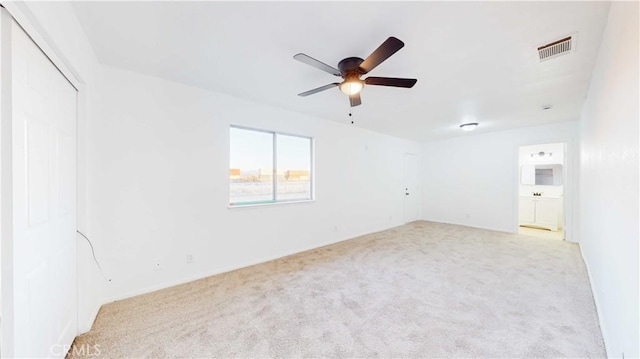 carpeted spare room featuring ceiling fan