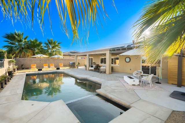 view of swimming pool featuring ceiling fan and a patio