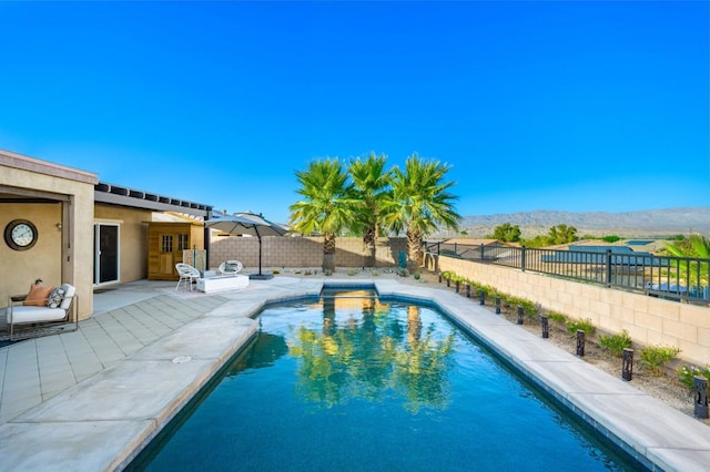 view of swimming pool with a mountain view and a patio