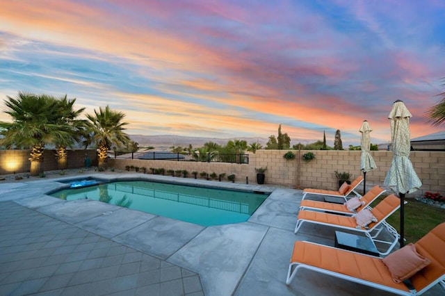 pool at dusk with a patio