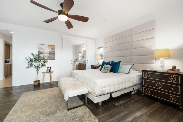 bedroom featuring ensuite bath, ceiling fan, and dark hardwood / wood-style flooring