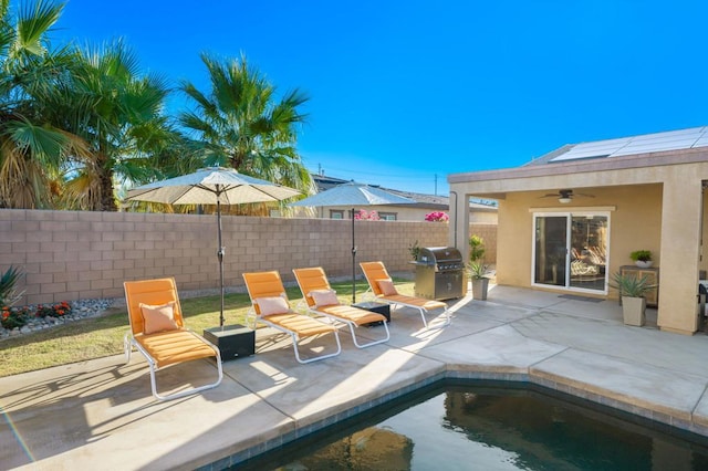 view of pool with ceiling fan, a grill, and a patio