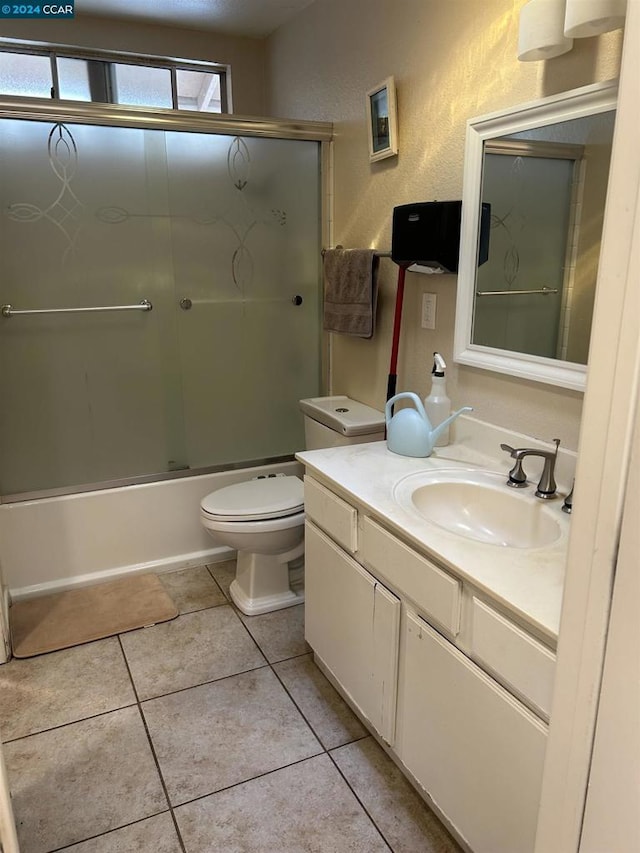 full bathroom featuring tile patterned floors, enclosed tub / shower combo, vanity, and toilet