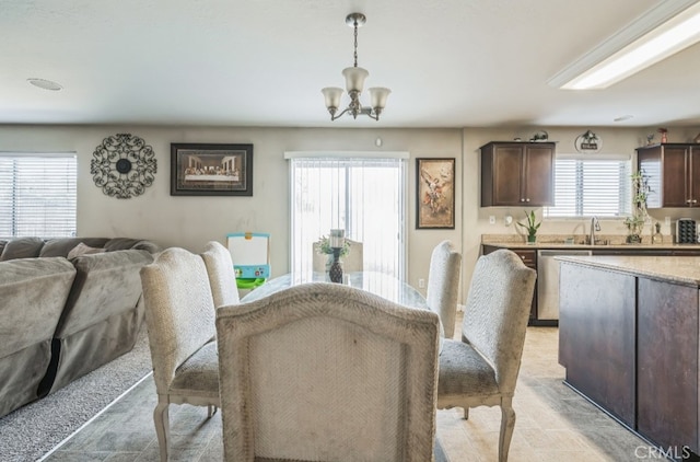 carpeted dining room featuring a chandelier and sink