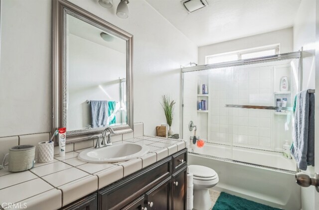 full bathroom with vanity, toilet, and combined bath / shower with glass door