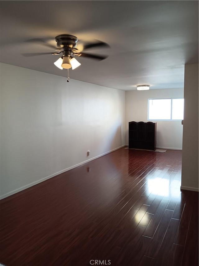 empty room with ceiling fan and dark wood-type flooring