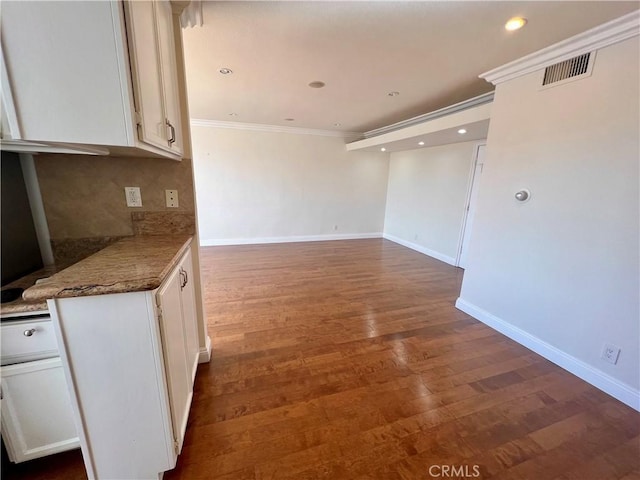 kitchen featuring white cabinets, dark hardwood / wood-style floors, and ornamental molding