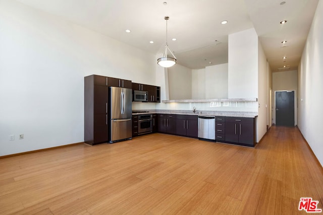 kitchen with appliances with stainless steel finishes, light hardwood / wood-style flooring, sink, and dark brown cabinets