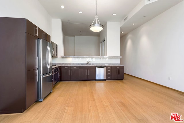 kitchen with light hardwood / wood-style flooring, sink, dark brown cabinetry, pendant lighting, and appliances with stainless steel finishes