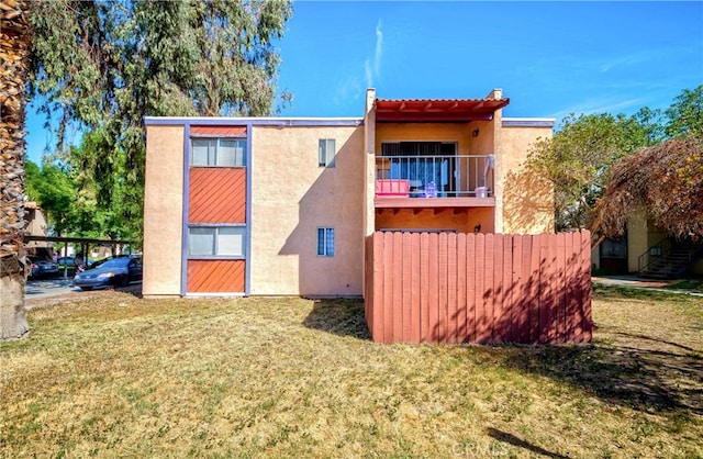 exterior space with a balcony and a yard