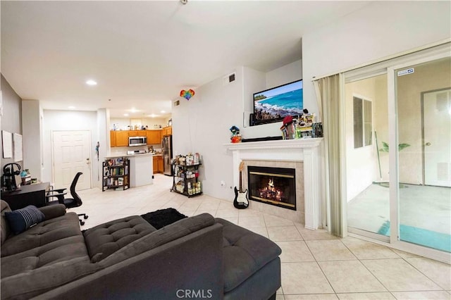 living room with a fireplace and light tile patterned floors