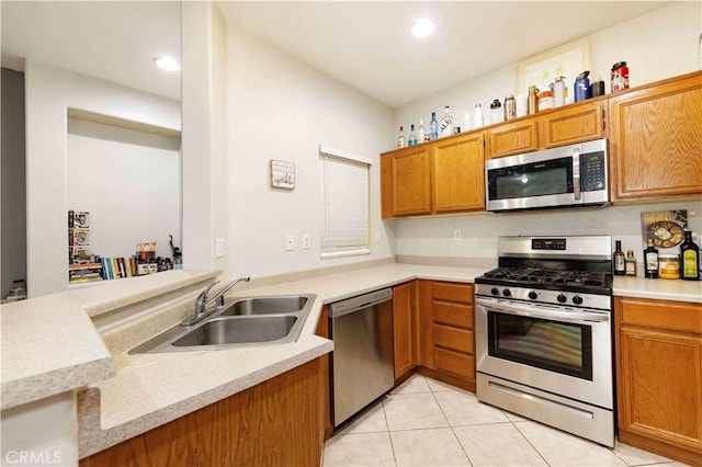 kitchen with kitchen peninsula, sink, light tile patterned flooring, and stainless steel appliances