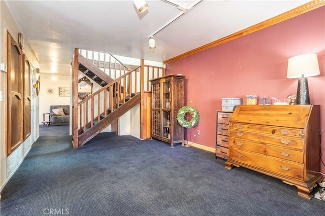 interior space featuring track lighting, dark carpet, and crown molding