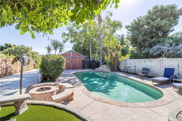 view of pool with a patio area and a fire pit