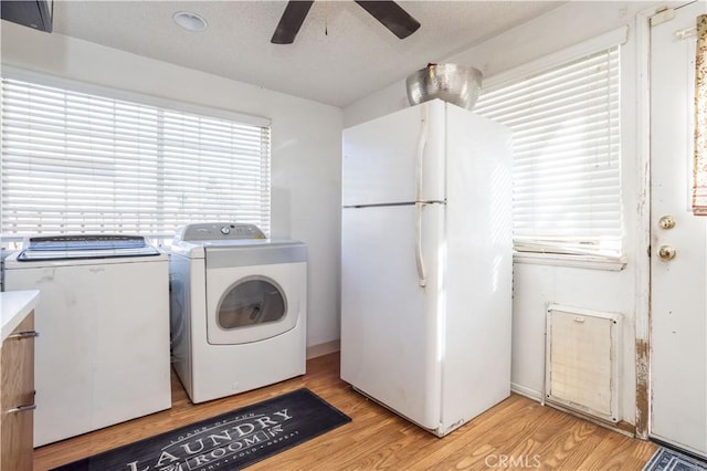 laundry room with washer and dryer, light hardwood / wood-style floors, and ceiling fan