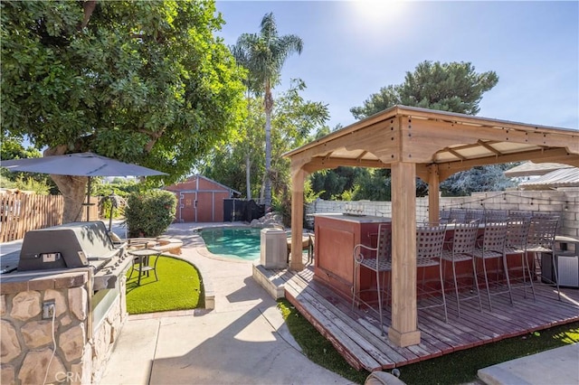 view of patio / terrace featuring a pool side deck, a bar, exterior kitchen, and a gazebo