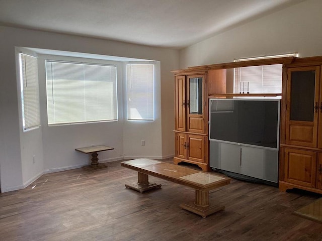 unfurnished living room featuring dark wood-type flooring and vaulted ceiling