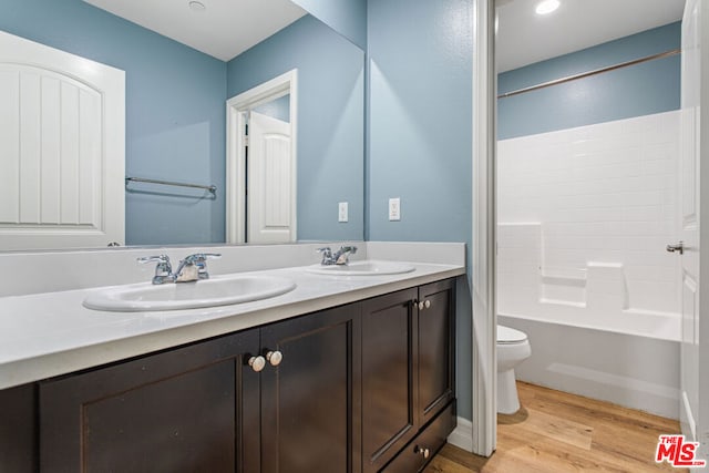 full bathroom featuring vanity, toilet, wood-type flooring, and shower / tub combination