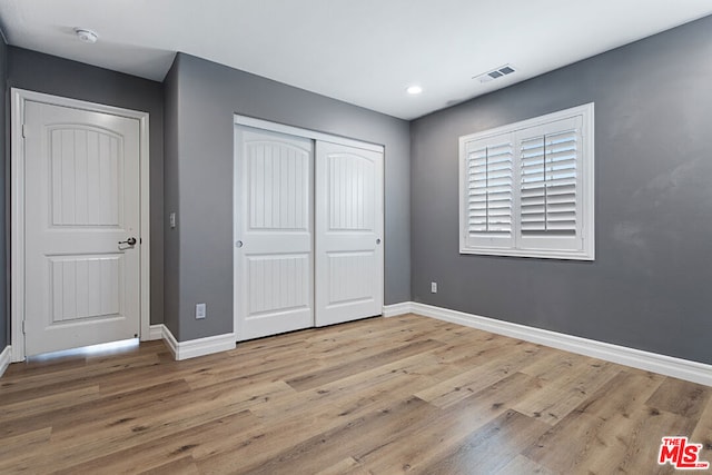 unfurnished bedroom featuring a closet and light hardwood / wood-style floors