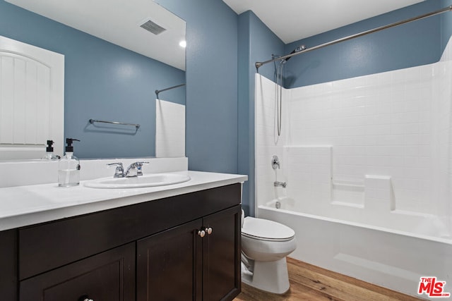 full bathroom with toilet, shower / bathing tub combination, hardwood / wood-style floors, and vanity