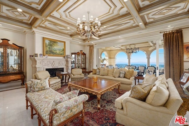 living room with a water view, crown molding, coffered ceiling, and a high end fireplace