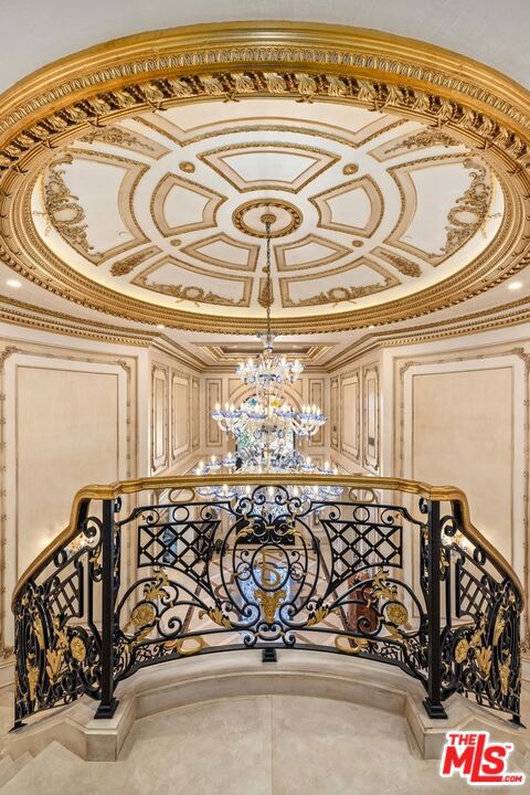 stairs featuring crown molding and an inviting chandelier