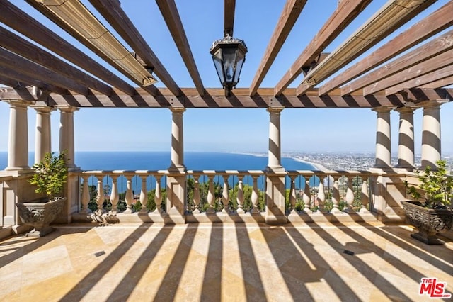 view of patio with a water view and a pergola