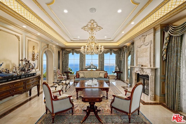 sitting room featuring a raised ceiling, a water view, crown molding, a premium fireplace, and an inviting chandelier