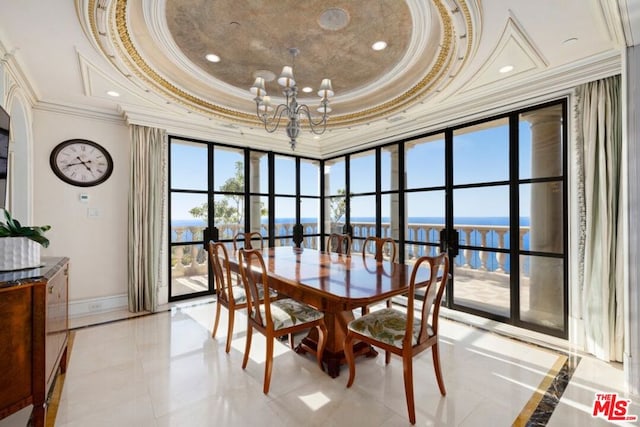 dining room with ornamental molding, a water view, light tile patterned floors, and a raised ceiling