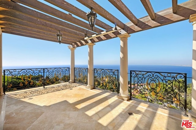 view of patio with a water view and a pergola