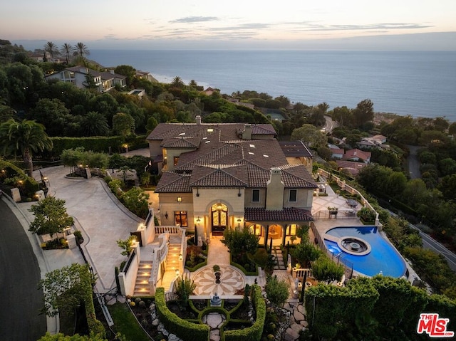 aerial view at dusk featuring a water view