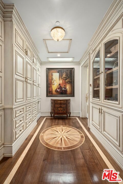 hallway with crown molding and dark wood-type flooring