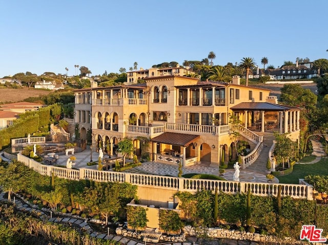 back of property with a gazebo and a balcony