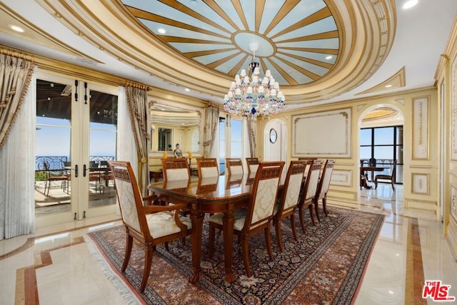 dining area featuring ornamental molding, a chandelier, a tray ceiling, and french doors