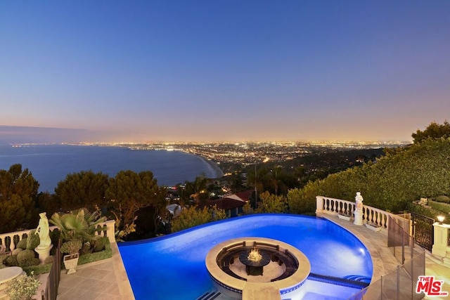 pool at dusk featuring a patio area