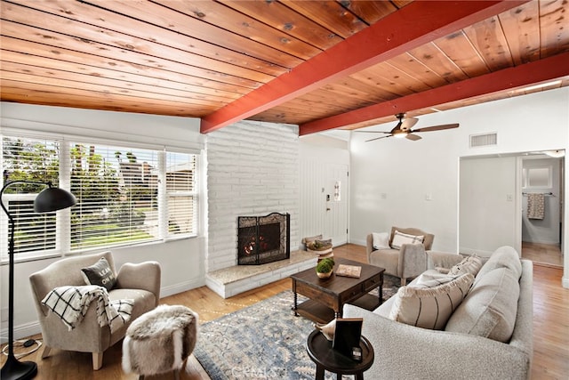 living room with vaulted ceiling with beams, a fireplace, light wood-type flooring, ceiling fan, and wooden ceiling