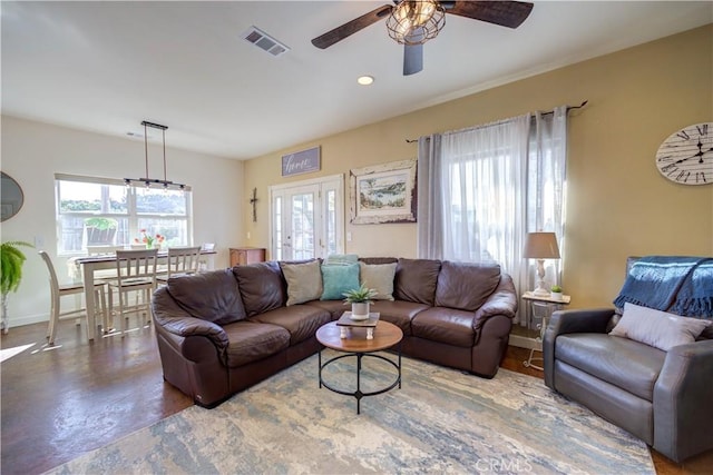 living room featuring concrete floors, ceiling fan, and french doors