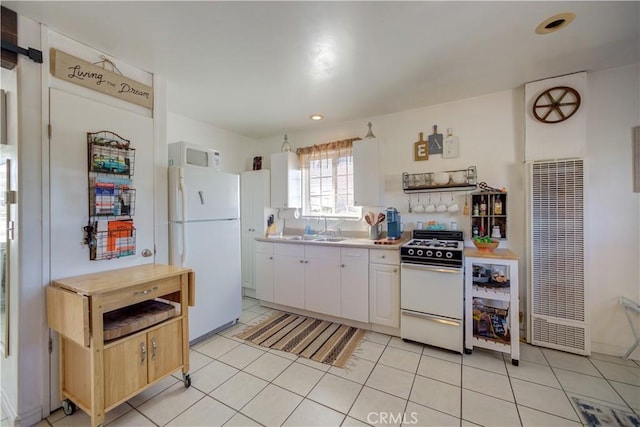 kitchen featuring white cabinetry, white appliances, light tile patterned flooring, and sink