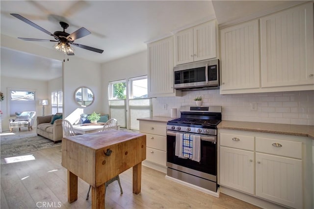 kitchen featuring stainless steel appliances, tasteful backsplash, and light wood-type flooring