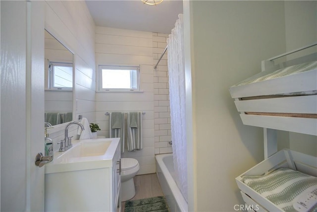 full bathroom with toilet, shower / tub combo, tile walls, vanity, and hardwood / wood-style flooring